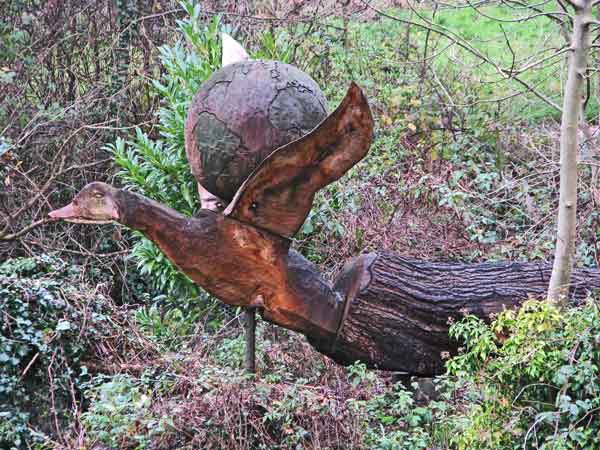 sculpture of duck resting on world globe