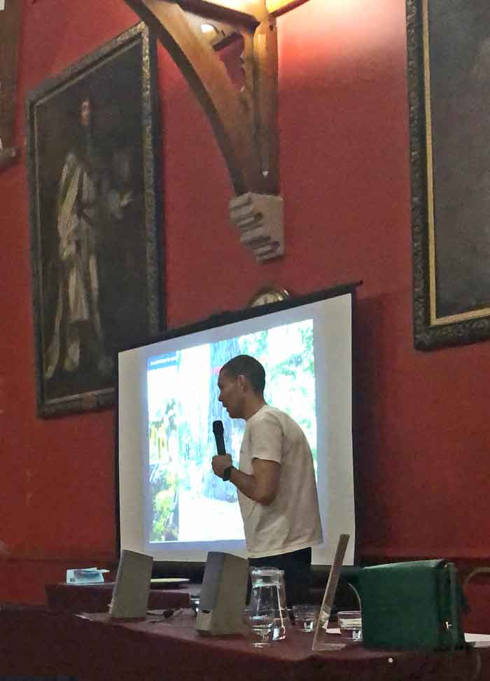Man in front of screen giving talk